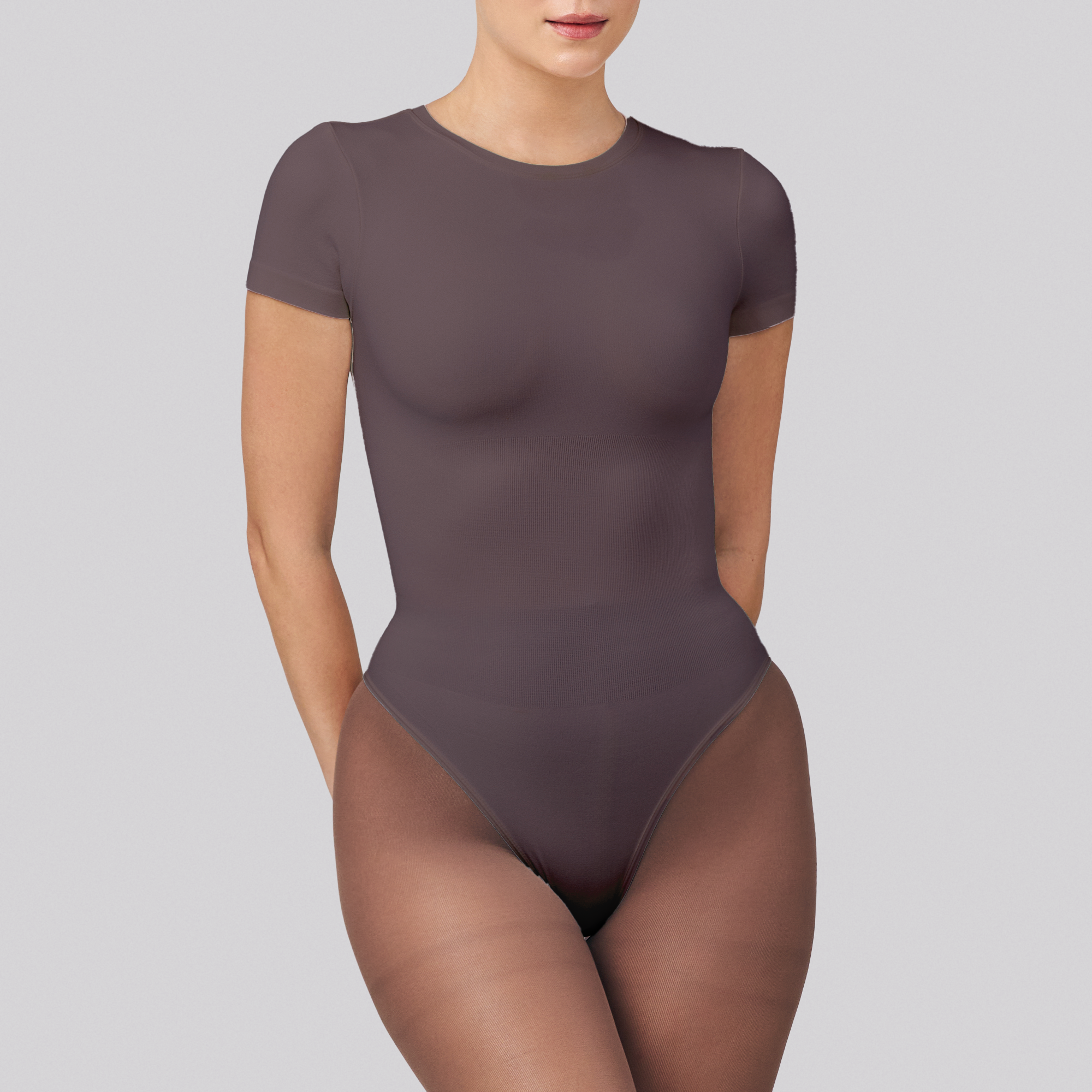 Brown bodysuit worn by a model on a gray background