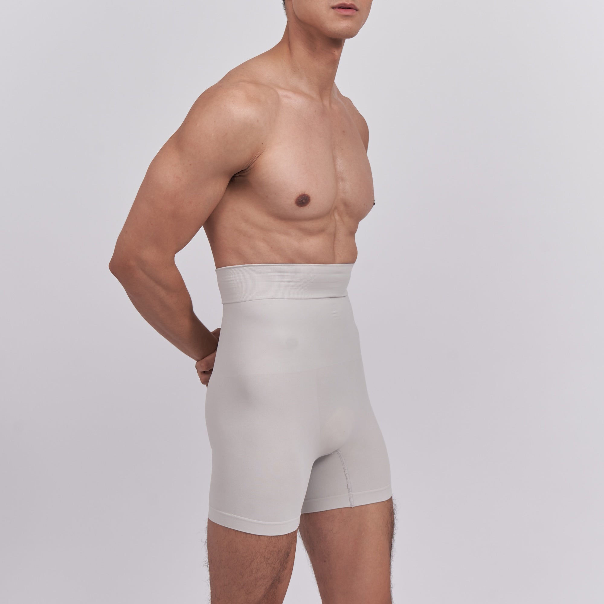 Man wearing beige compression shorts on a plain background