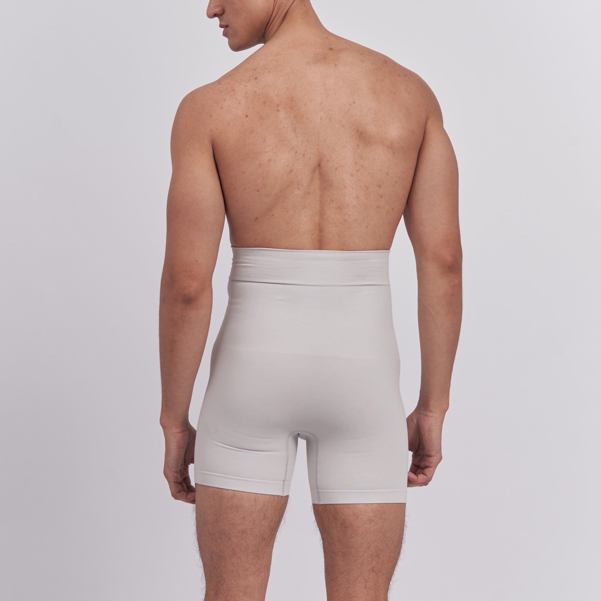 Man wearing beige boxer briefs on a plain background