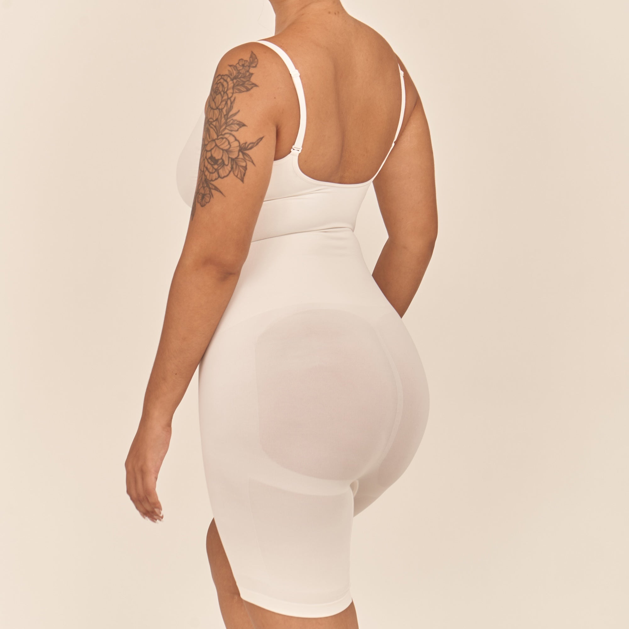 Person wearing a white dress with a neutral background