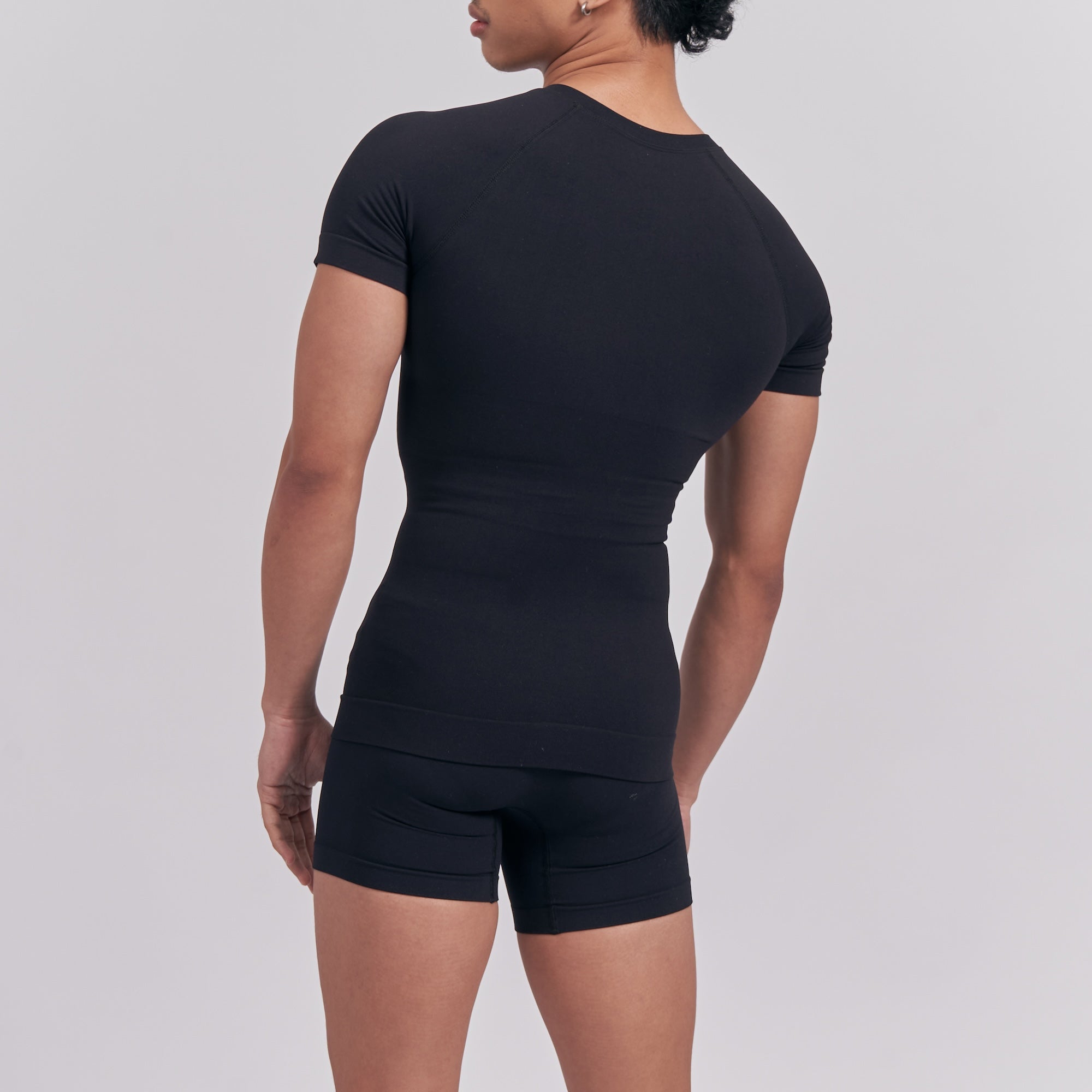 Person wearing a black outfit on a plain background