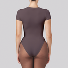 Brown bodysuit worn by a model on a gray background