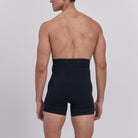 Person wearing black boxer briefs on a plain background