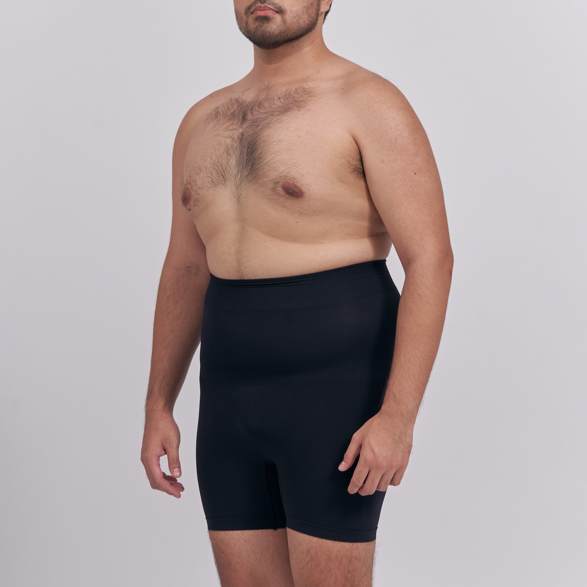 Man wearing a black compression garment against a plain background