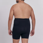 Man wearing black underwear on a plain background