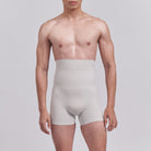 Man wearing light gray underwear against a plain background