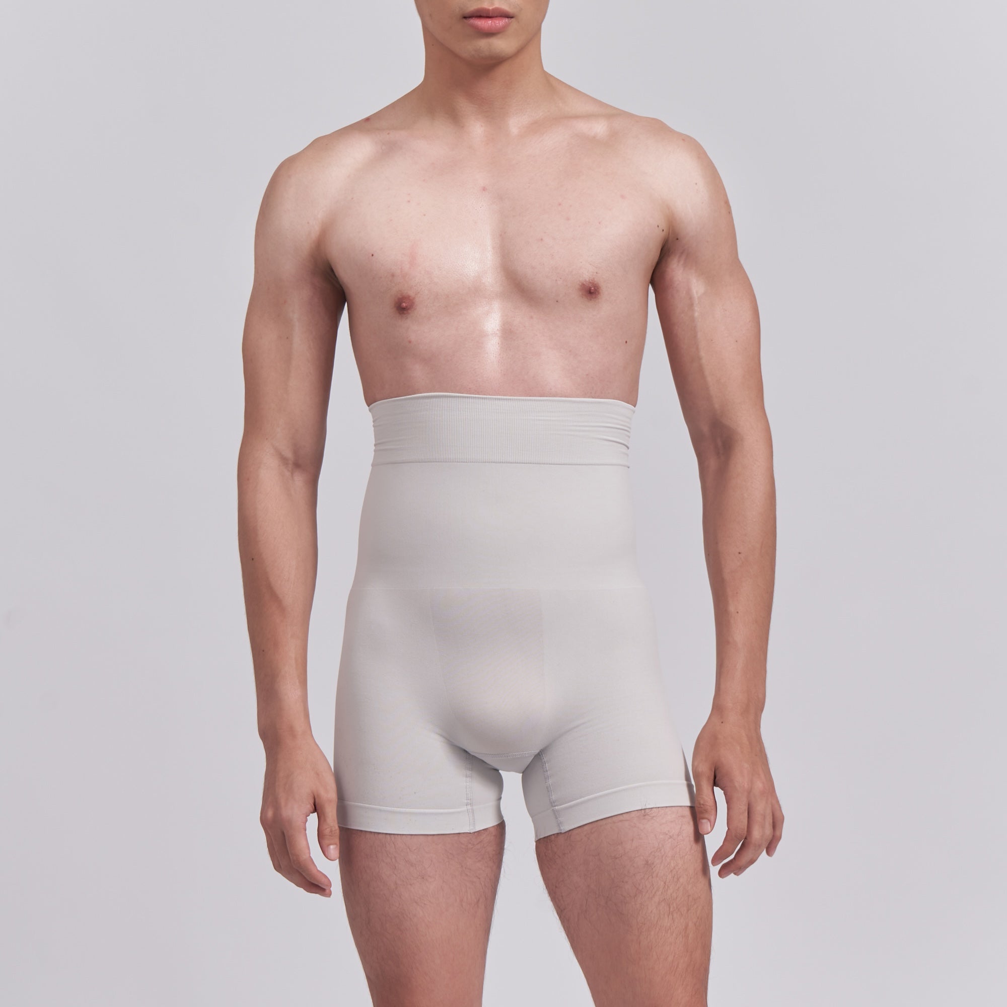 Man wearing light gray underwear against a plain background