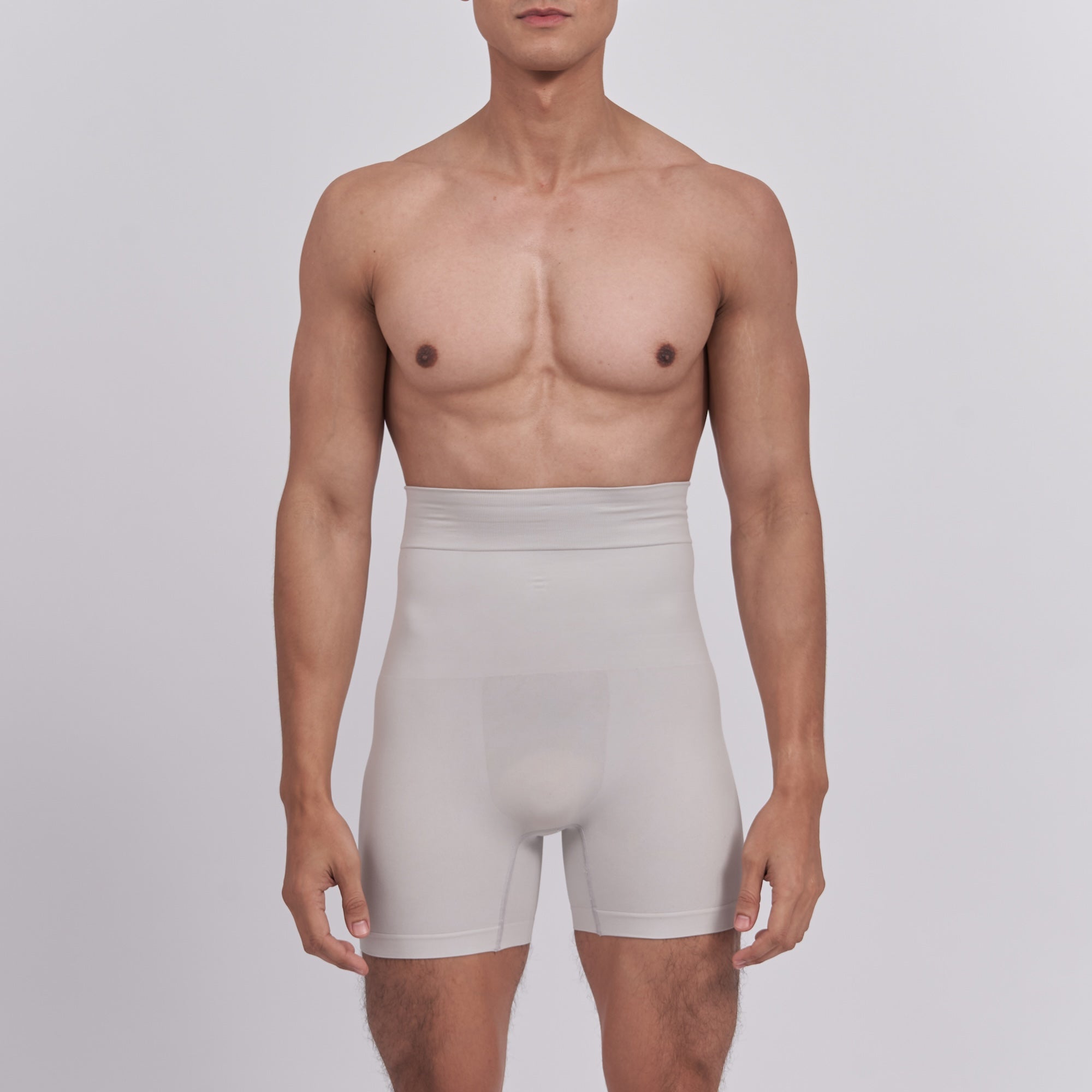 Man wearing beige compression shorts against a plain background