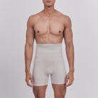 Man wearing beige compression shorts against a plain background