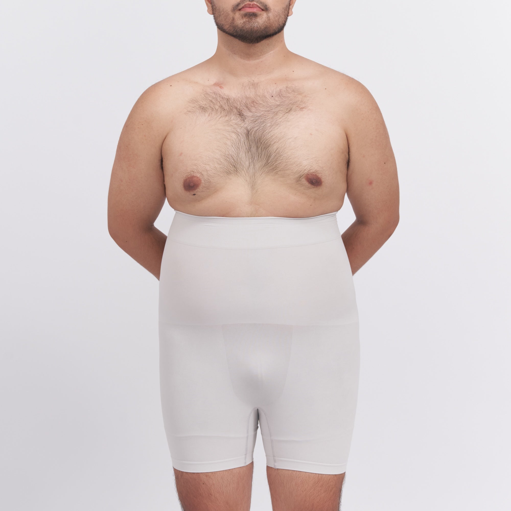 Man wearing a white compression garment against a plain background