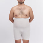 Man wearing a white compression garment against a plain background