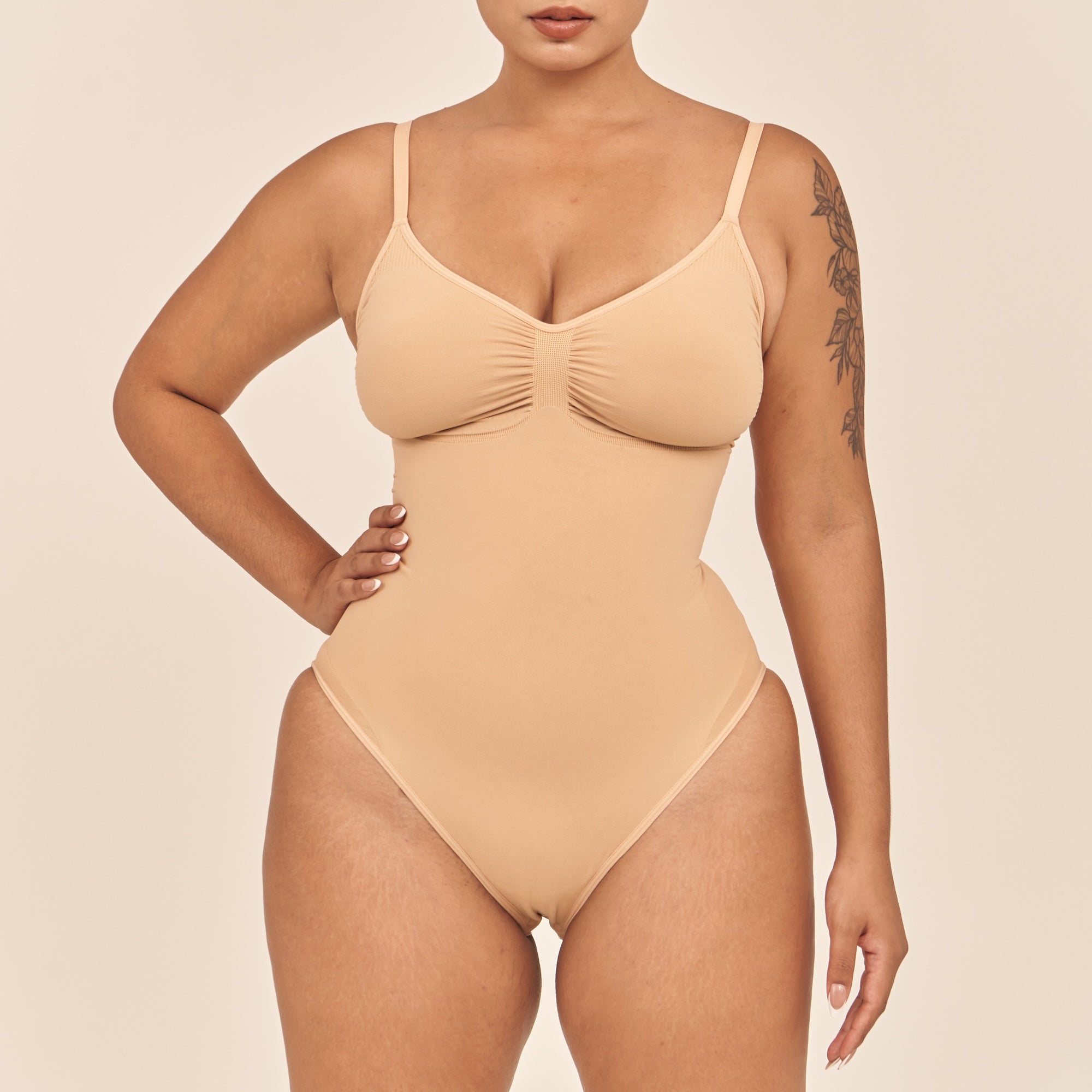 Beige swimsuit worn by a model on a beige background