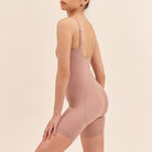 Person wearing a beige shapewear garment on a plain background
