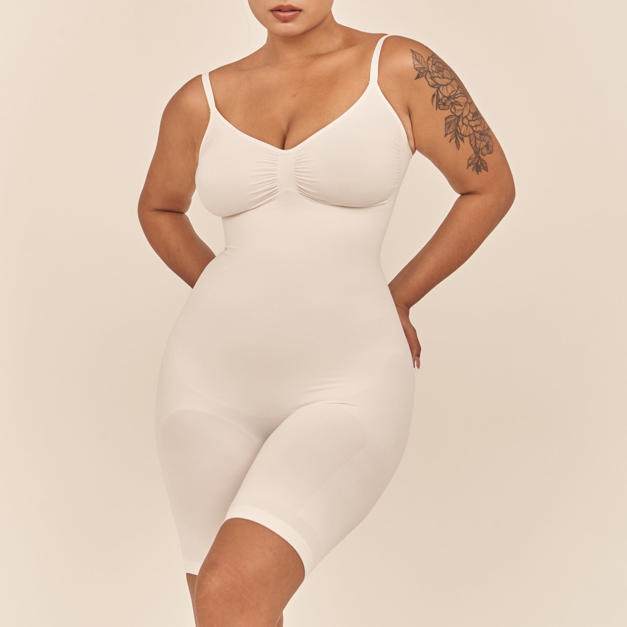 Woman wearing a white shapewear dress against a beige background