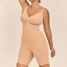 Woman wearing a beige bodysuit against a plain background