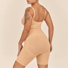 Person wearing a beige bodysuit against a beige background