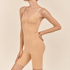 Beige bodysuit worn by a model on a beige background