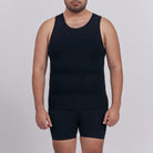Person wearing a black tank top and shorts on a plain background