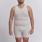 Man wearing a beige tank top and shorts set on a plain background