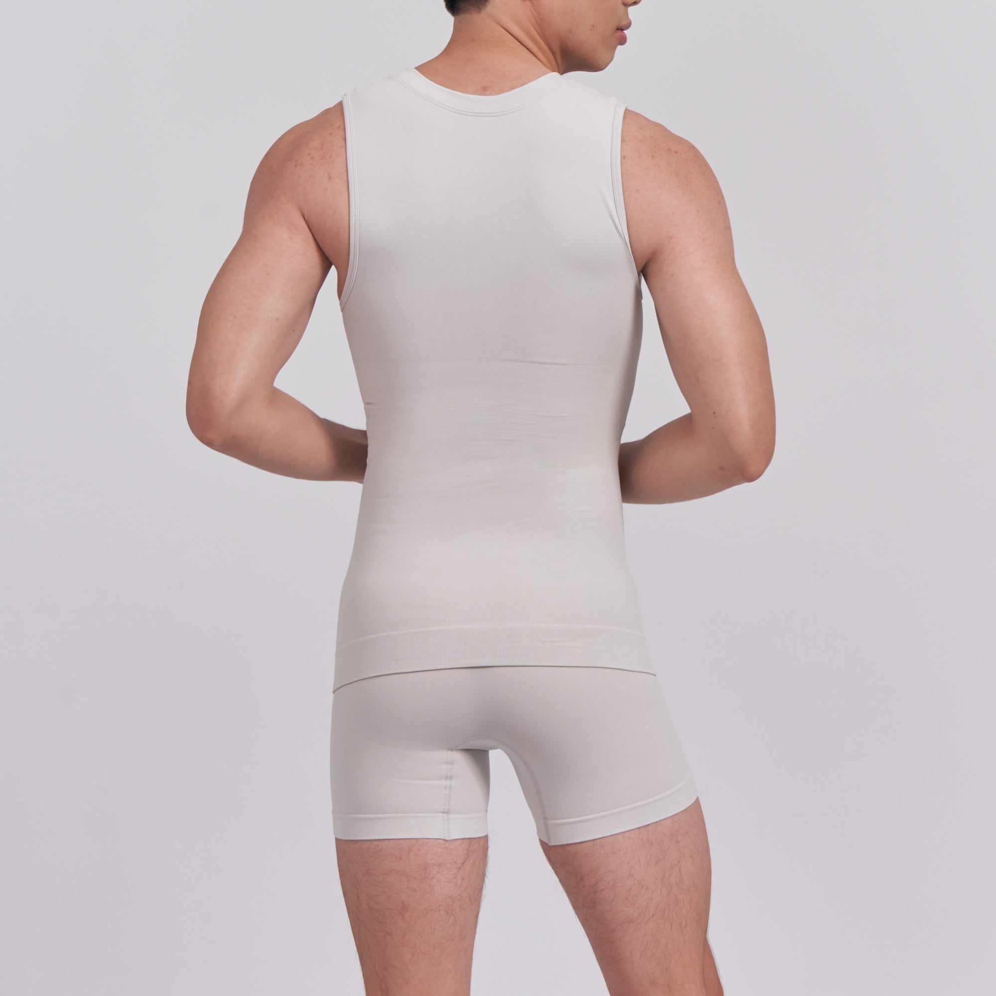 Person wearing a beige compression garment on a plain background