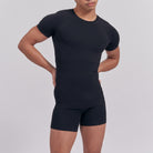 Person wearing a black athletic outfit on a plain background