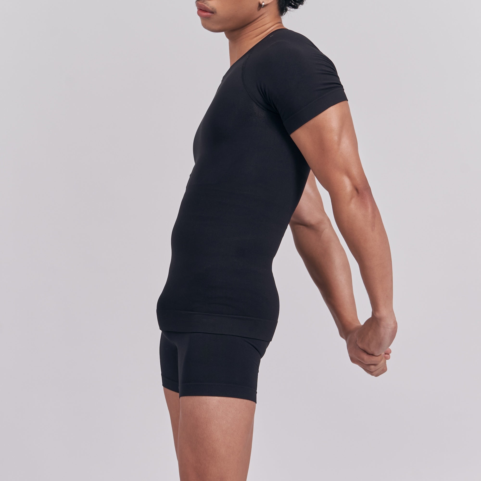 Person wearing a black athletic outfit on a light gray background