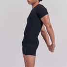 Person wearing a black athletic outfit on a light gray background