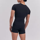 Person wearing a black outfit on a plain background