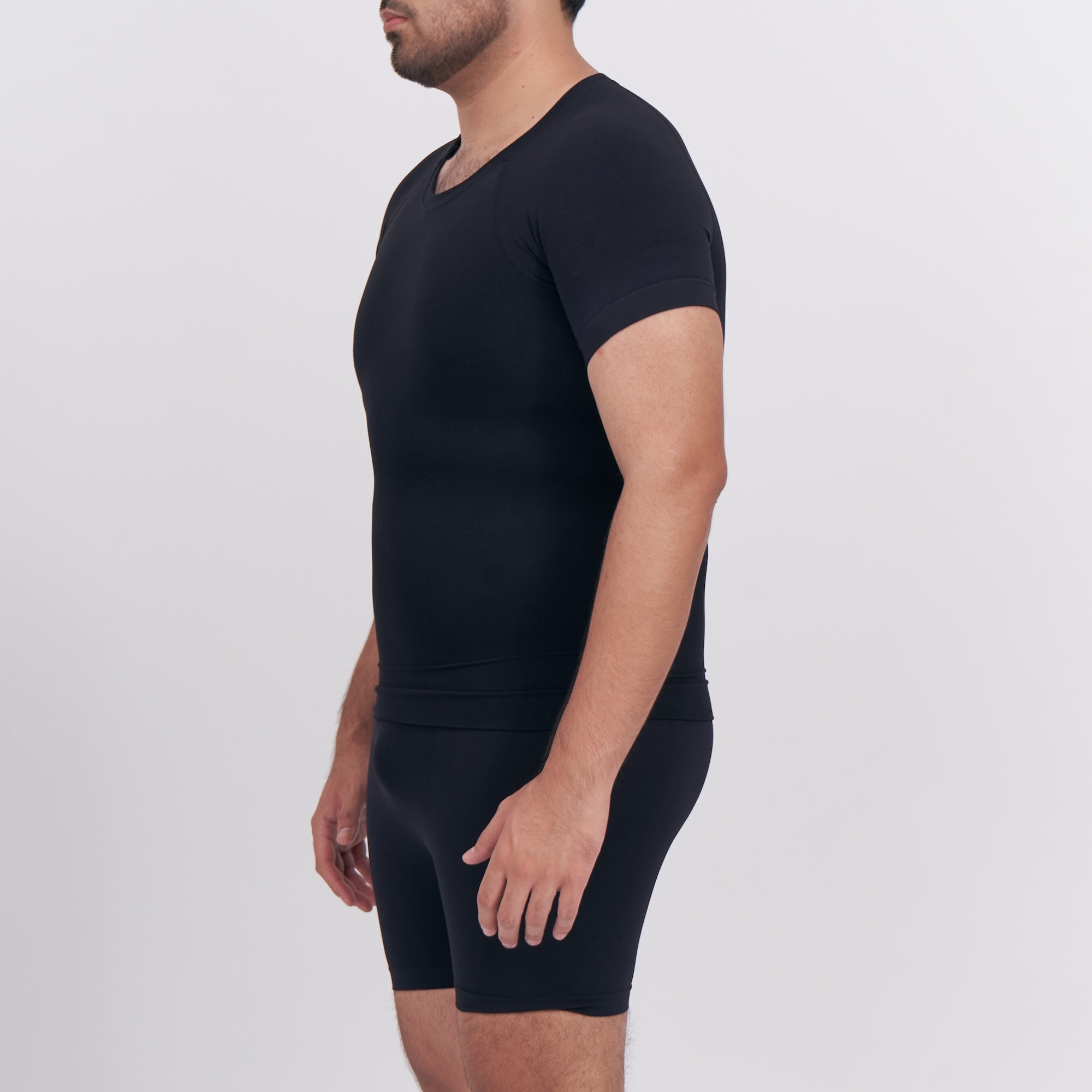 Person wearing a black t-shirt and black shorts on a white background