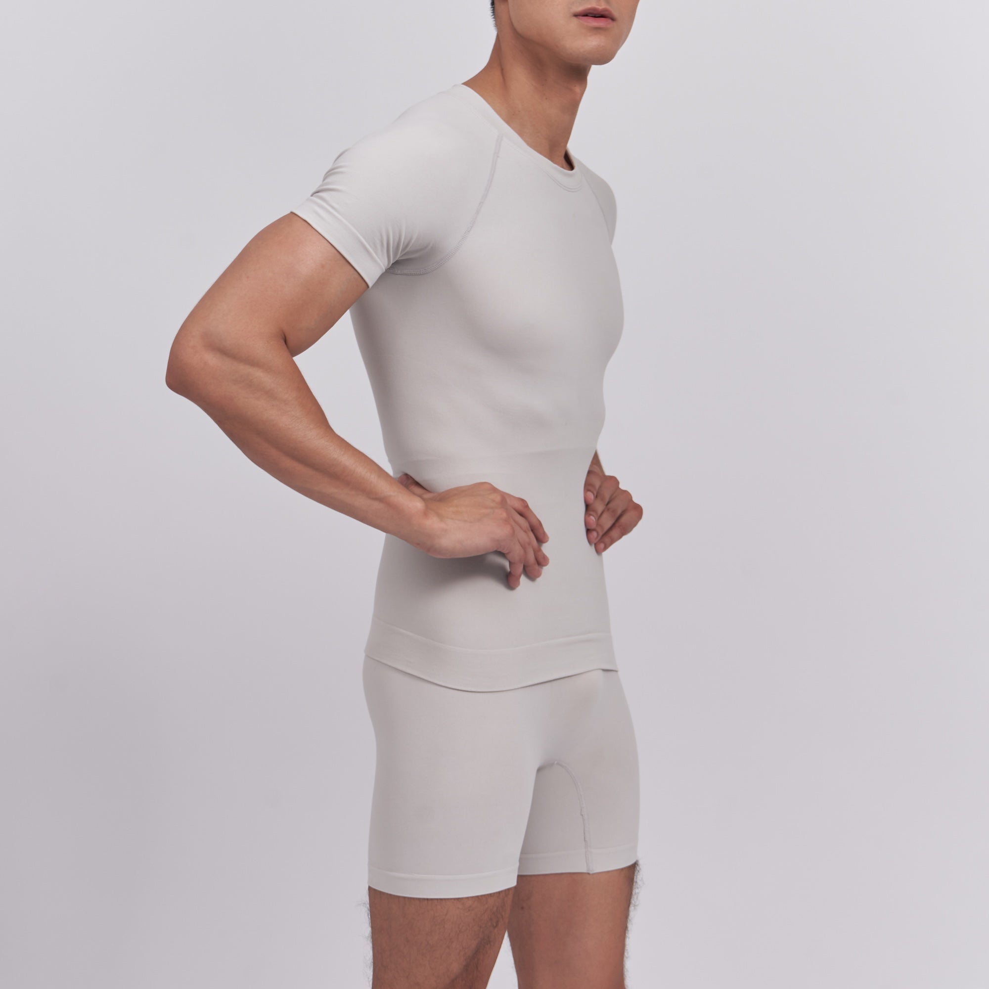 Man wearing a fitted beige shirt and shorts set on a plain background