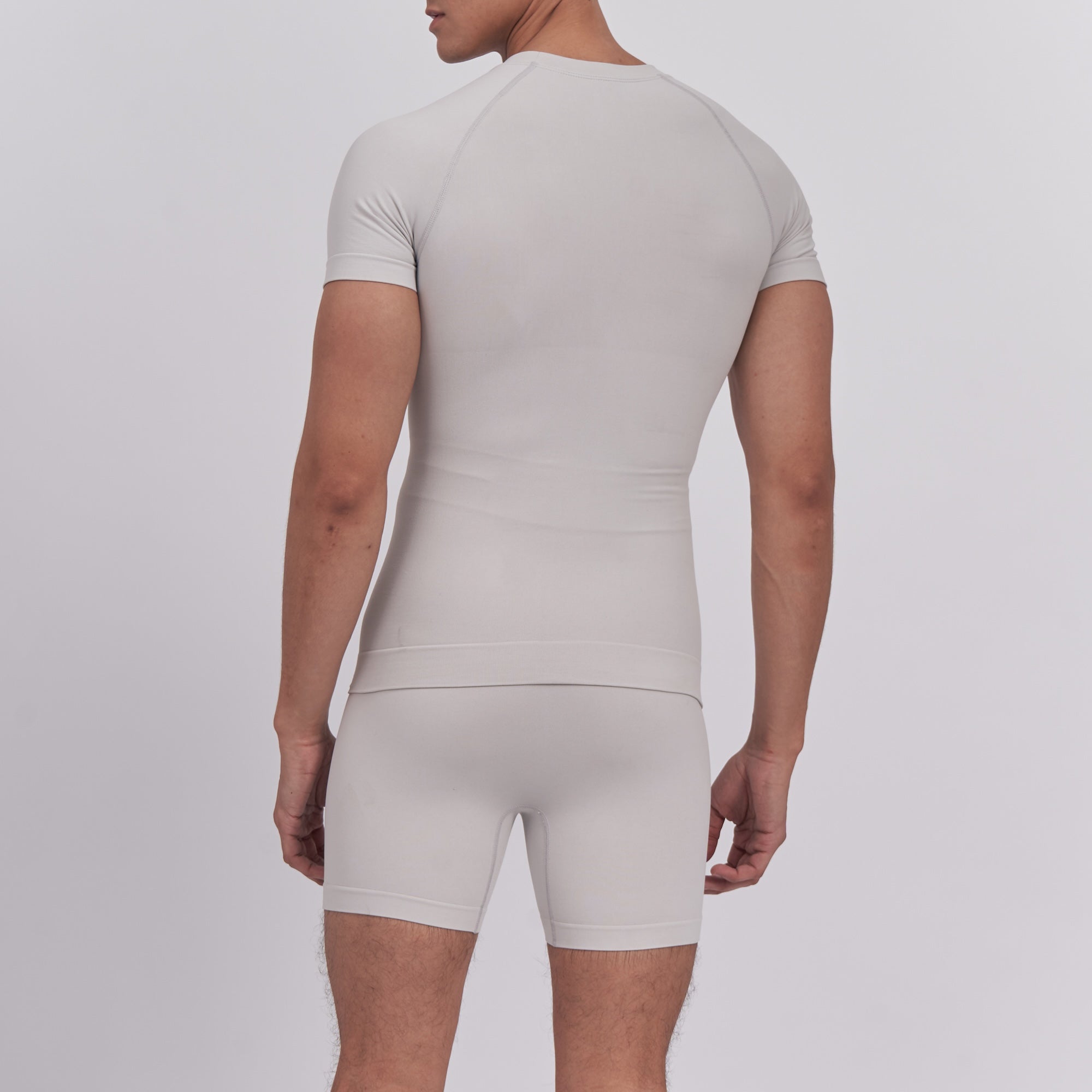 Person wearing a beige compression garment on a plain background