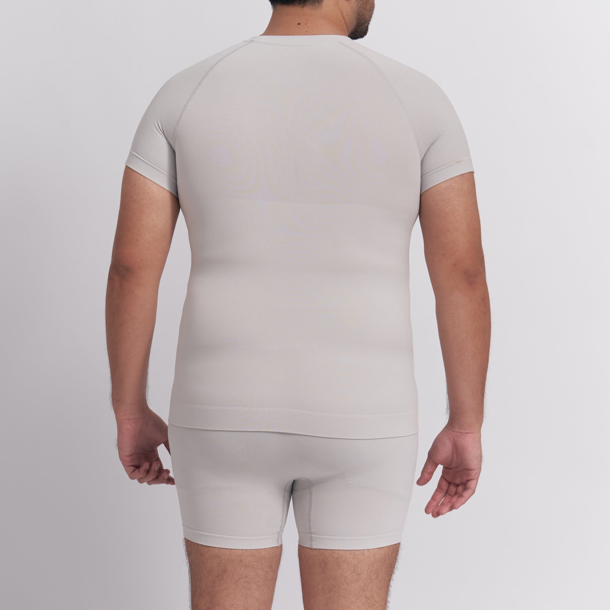 Person wearing a beige compression garment on a plain background