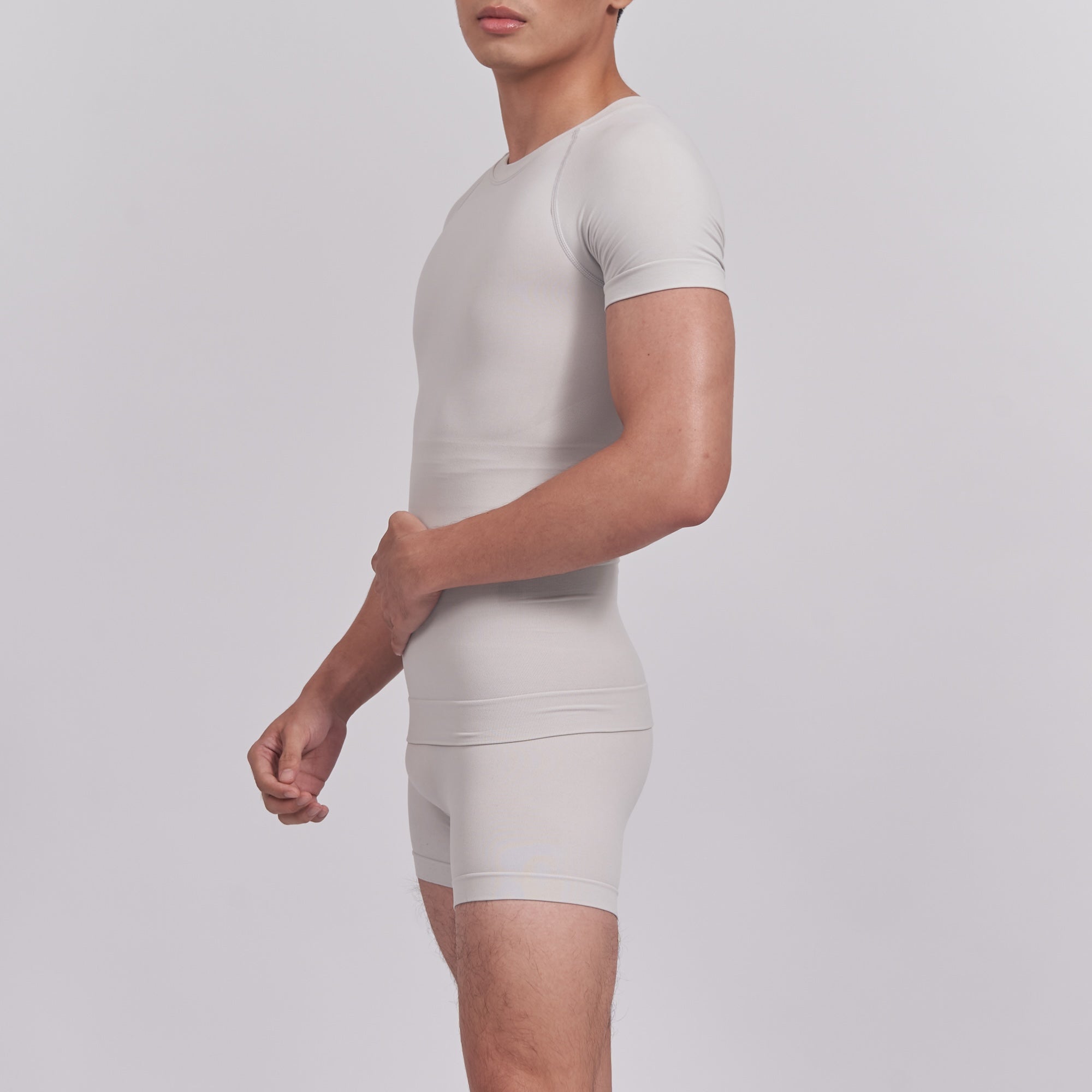 Person wearing a white compression garment on a plain background