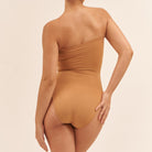 Brown swimsuit worn by a person on a beige background