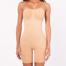 Beige strapless bodysuit worn by a model on a white background